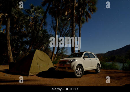 Zelt und Safari Fahrzeug in der Nacht auf einem Campingplatz in der Nähe von Epupa Wasserfälle, Epupa, Kaokoland, Kunene, Namibia Stockfoto