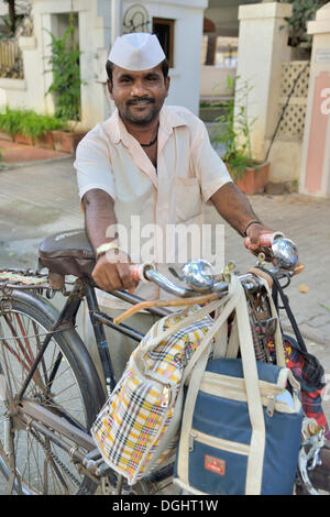 Dabba Wallah oder Lebensmittel-Lieferung-Mann mit den typischen weißen Kappe und Taschen voller Essen, Mumbai, Maharashtra, Indien Stockfoto