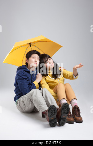 ein paar tragen Wanderausrüstung unter einem Regenschirm Stockfoto