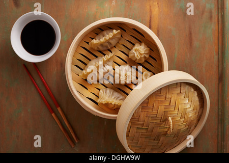 Hausgemachte Dim Sum asiatische Teigtaschen auf einem traditionellen Bambus-Dampfer Stockfoto