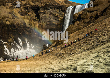 Touristischen Gruppe Wandern vor der Skógafoss Wasserfall, Skógar, Rangarþing Eystra, Region Süd, Island Stockfoto