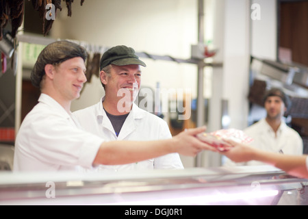 Männer, die für Kunden auf Metzgerei Theke Stockfoto