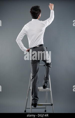 ein Business-Mann auf einer Leiter Stockfoto