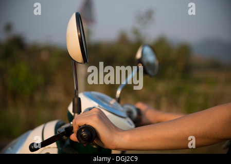 Frauenhand auf Moped-Lenker Stockfoto