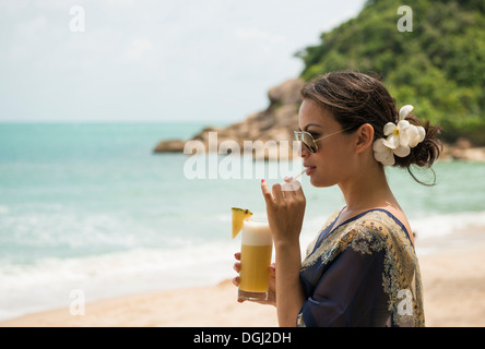 Frau trinken am Strand, dieser Tree Resort, Ko Samui, Thailand Stockfoto