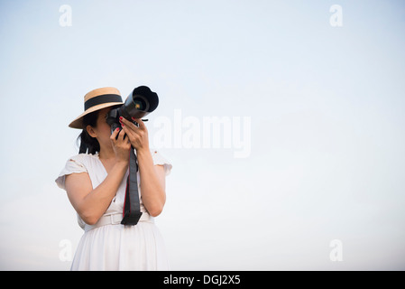 Frau nehmen Foto gegen klaren Himmel Stockfoto