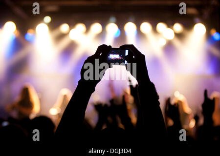 Ein Fan nimmt ein Bild mit kleinen Digitalkamera beim Konzert der Schweizer Pagan-Metal-Band Eluveitie live in der Schueuer Halle Stockfoto