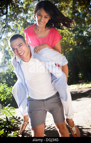 Junger Mann mit Frau Huckepack Stockfoto