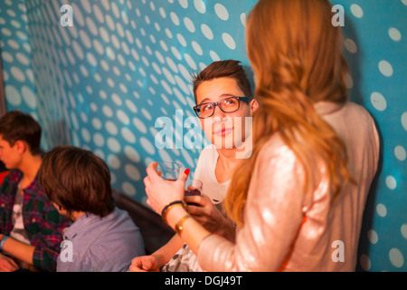 Teenager-Jungen blickte zu Teenager-Mädchen, Freunde im Hintergrund Stockfoto