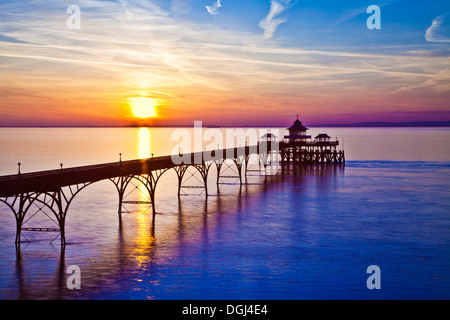 Die Sonne geht über den Bristolkanal hinter dem Pier in Clevedon in Somerset. Stockfoto