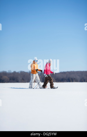 Erwachsene Paare, die auf Schnee Stockfoto