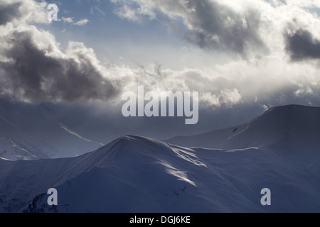 Abend-Berg und Sonnenlicht-Wolken. Anzeigen von Skipisten. Kaukasus, Georgien, Gudauri. Stockfoto