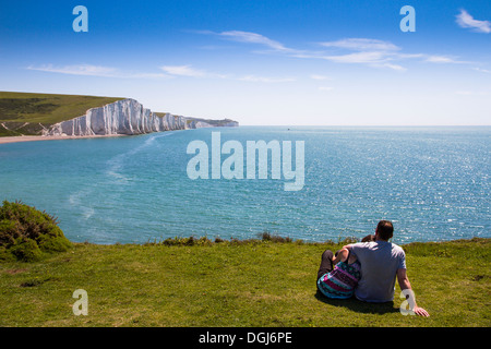 Ein paar auf den Klippen mit Blick auf die Kreidefelsen bekannt als die sieben Schwestern. Stockfoto