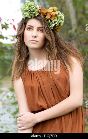 Junge Frau mit einem flowal Kranz im Haar, im freien Stockfoto