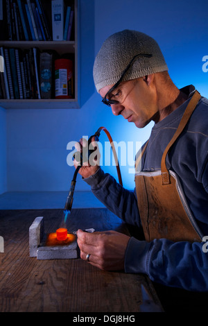 Mann mit einer Lötlampe auf eine Workshop-Bank. Stockfoto