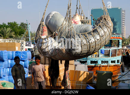 Ausländische Arbeitnehmer laden Fracht in die Dhow Hafen von Dubai, Vereinigte Arabische Emirate, Naher Osten Stockfoto