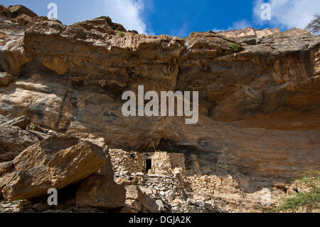 Stein-Hütten der verlassenen Siedlung von Sap Bani Khamis unter einem Felsvorsprung in den Grand Canyon von Oman im Wadi bei Nakhar Stockfoto