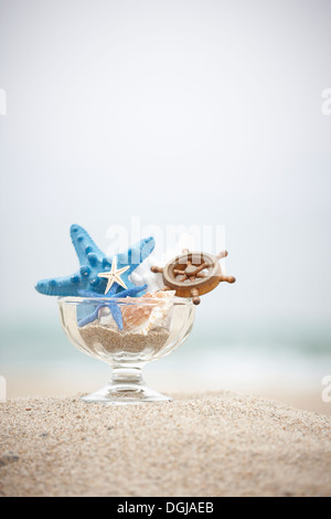 verschiedene Spielzeuge in einem Glas am Strand Stockfoto