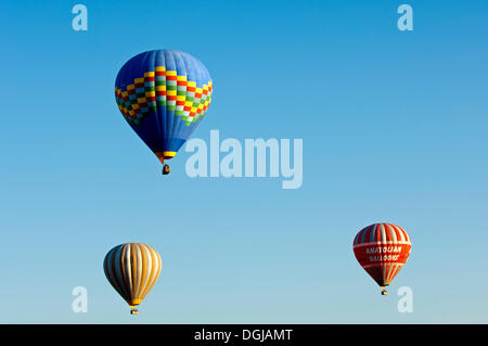 Heißluftballons schweben vor blauem Himmel, Göreme, Kappadokien, Nevşehir Provinz, Zentralregion Anatolien, Türkei Stockfoto