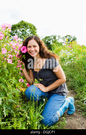 Porträt der jungen Frau, die rosa Blume in Zuteilung Stockfoto