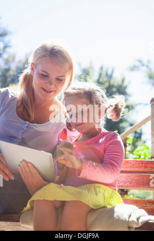 Mutter und Tochter mit Laptop im Garten Stockfoto