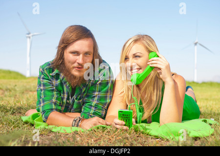 Junges Paar liegen im Bereich Frau auf grün Handy Stockfoto