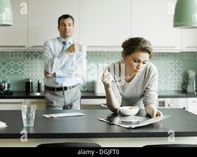 Mitte erwachsenen Frau liest Dokument über das Frühstück in der Küche Stockfoto