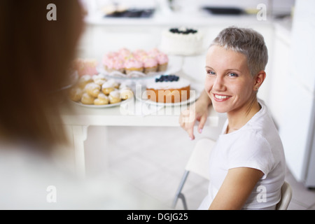 Zwei Frauen mit Kuchen im Hintergrund Stockfoto