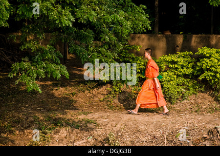 Ein junger buddhistischer Mönch zu Fuß einen Weg am Ufer des Chao Praya River in Bangkok. Stockfoto