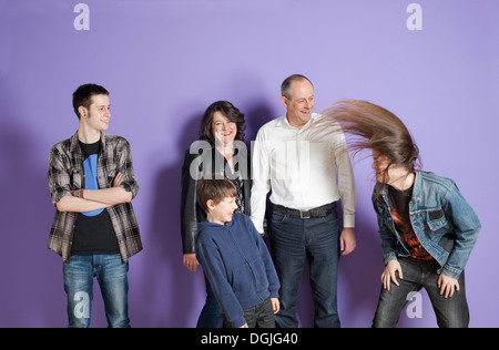 Familie vor dem Sohn Headbang vor lila Hintergrund Stockfoto