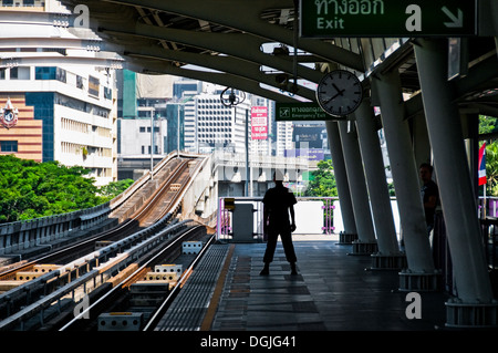 Die Silhouette von einem Wachmann auf der Plattform des Skytrain Haltestelle Ratchadamri Bangkok. Stockfoto