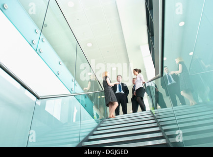 Kollegen, die stehend auf der Treppe im Bürogebäude Stockfoto