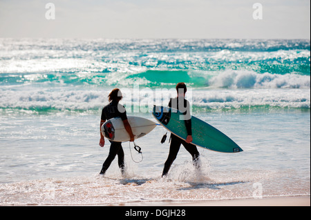 Surfer auf North Stradbroke Island in Queensland Zylinder Strand entlang spazieren. Stockfoto