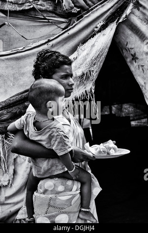 Niedrigere Kaste indischen Teenager-Mädchen und Sohn erhalten kostenloses Essen außerhalb ihrer Bender.  Andhra Pradesh, Indien. Monochrom Stockfoto