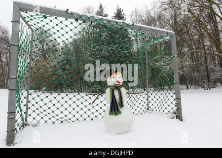 Lustiger Schneemann Fußballtor im Park zu verteidigen Stockfoto