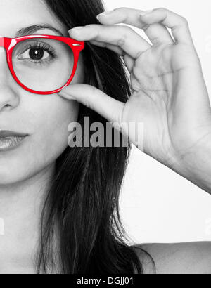 Halbe Porträt einer jungen Frau in schwarz und weiß mit roten Brille Stockfoto