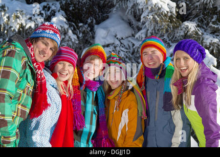 Gruppe von Jugendlichen vor einem schneebedeckten Fichtenwald, Salzburger Land, Flachau, Tirol, Österreich Stockfoto