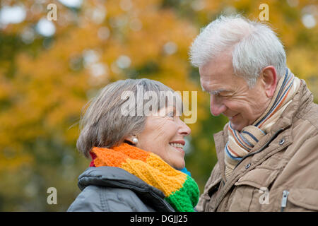 Älteres paar Lächeln einander vor herbstliche Bäume, Stadtpark, Berlin, Berlin, Deutschland Stockfoto