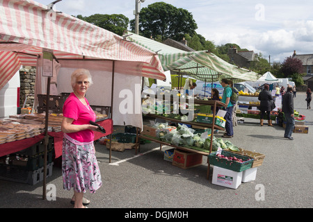 Bäckerei, Obst und Gemüse und Fisch Stände unter anderem auf dem Wochenmarkt am Joss Lane Parkplatz in Sedbergh, Cumbria. Stockfoto