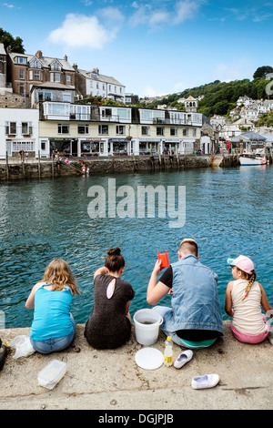 Vier junge Menschen auf dem Kai in Looe Verdrehungen. Stockfoto