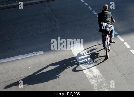 Berlin, Deutschland. 22. Oktober 2013. Ein Radfahrer wirft einen langen Schatten in der Friedrichstraße in Berlin, Deutschland, 22. Oktober 2013. Foto: BRITTA PEDERSEN/Dpa/Alamy Live News Stockfoto