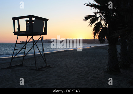 Sonnenuntergang über Dana Point Beach mit Palm-Baum und Rettungsschwimmer-Turm in Südkalifornien Stockfoto