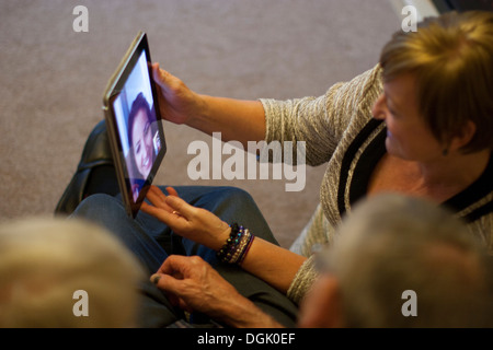Skype-Videoanruf läuft auf einem Apple iPad – Nutzer kommunizieren über die Skype-App, wobei mobile Videokonferenzen auf Tablet-Geräten, Großbritannien, hervorgehoben werden. Stockfoto