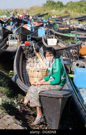 Ein junges Mädchen sitzen festgemachten Boote in einem kleinen Dorf von Inle See in Myanmar. Stockfoto