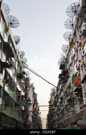 Eine hagere, graue Straße, gesäumt von Satellitenschüsseln in der Innenstadt von Yangon in Myanmar. Stockfoto