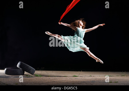 Ballett-Tänzerin springen Luft mit rotem Schal Stockfoto