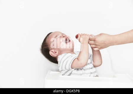 Hand nehmen Lutscher aus schreiendes baby Stockfoto