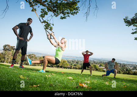 Junge Frau und Trainer mit einem Ausfallschritt Seil im Feld Stockfoto