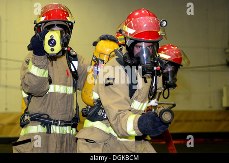 Matrosen üben Brandbekämpfung Techniken während einer allgemeinen Viertel Drill an Bord des Flugzeugträgers USS Ronald Reagan (CVN-76). Ronald Reagan führt technische Übungen im Gange. Stockfoto