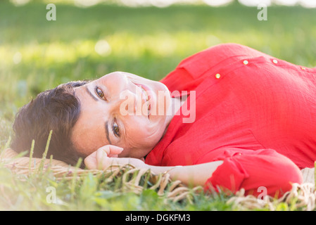 Reife Frau liegend auf dem Rasen Stockfoto